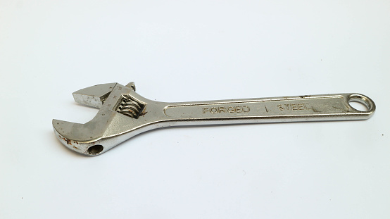 Old adjustable wrench isolated over white