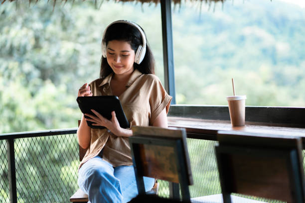istock Woman Adult Student studying online class with Virtual Tutor reskill on her work at the park 1429350334