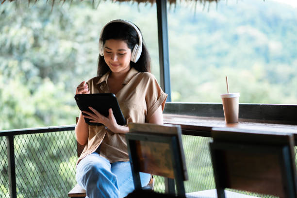 Woman Adult Student studying online class with Virtual Tutor reskill on her work at the park Mature female Adult Student studying online class in the park nature park stock pictures, royalty-free photos & images