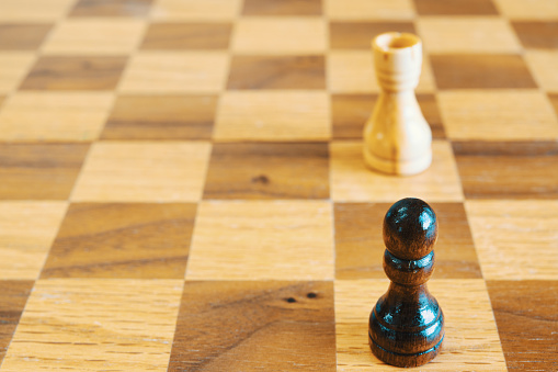 Chechered board under white pieces as a strategy backdrop