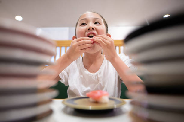 child eating sushi child eating sushi kids eating tuna stock pictures, royalty-free photos & images