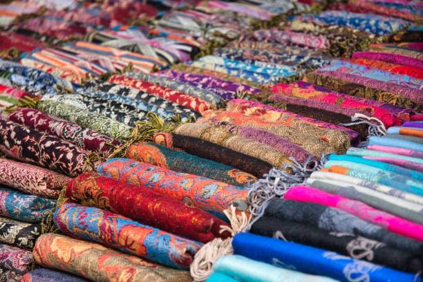 Lao Silk scarf at Night Market at Lunag Prabang with Wat May Souvannapoumaram in the background, Laos PDR Lao Silk scarf at Night Market at Lunag Prabang with Wat May Souvannapoumaram in the background, Laos PDR pashmina stock pictures, royalty-free photos & images