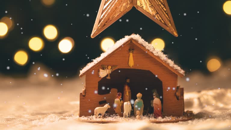 Christmas Star Hanging Over Nativity Scene With Snow Falling