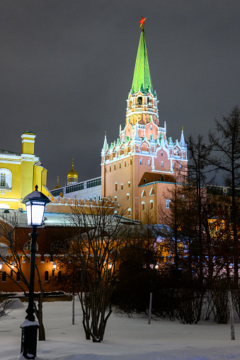 Moscow, Russia - January 17, 2022: Spasskaya tower and winter Kremlin against the backdrop of street Christmas decorations on Red Square on the New Year. The christmas Moscow. The snowstorm.