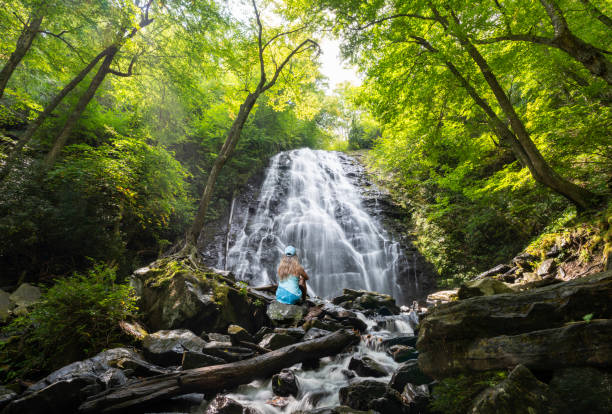 istock Woman relaxing by the  beautiful waterfall. 1429372630