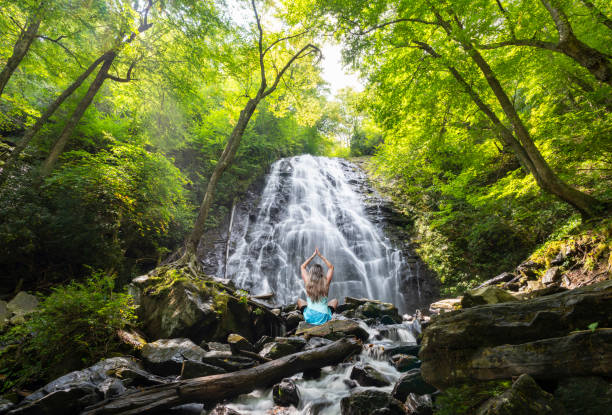 istock Woman practicing yoga in nature by the waterfall. 1429372642