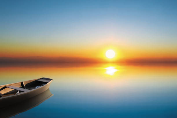 Blured mirror sunset with vintage wooden row boat and beautiful lake and colorful blue sky