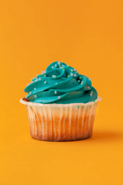 istock Delicious cupcakes with icing on a yellow background 1429383645