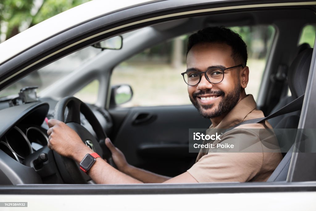 Smiling young man driving a car Behind the wheel. Transportation, car rental, credit, buying a car, lifestyle, business concept Driving Stock Photo