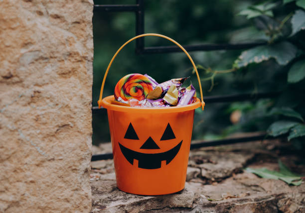 Halloween Jack o Lantern orange bucket with candy and sweet treats outdoor stock photo