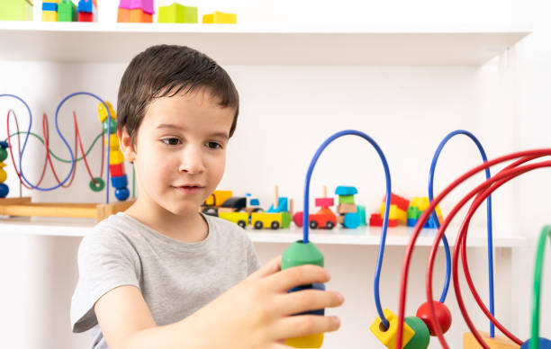 istock boy playing with colorful wooden rollercoaster maze 1429385833