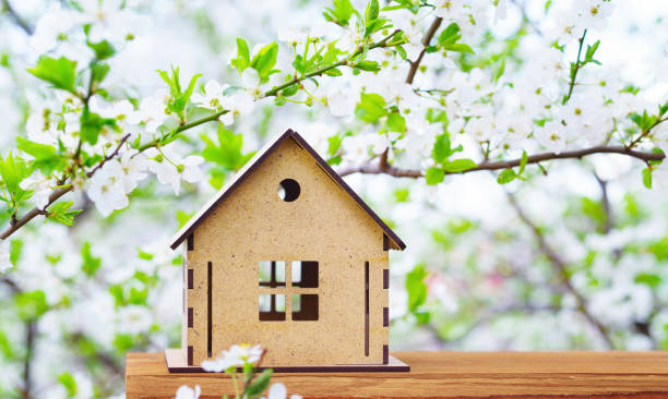 casa de madera de juguete bajo un árbol en flor - birdhouse house bird house rental fotografías e imágenes de stock