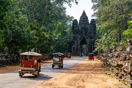 Cambodia. Siem Reap. The archaeological park of Angkor. Tuk tuk taking tourists to Bayon Temple 12th Century Hindu Temple