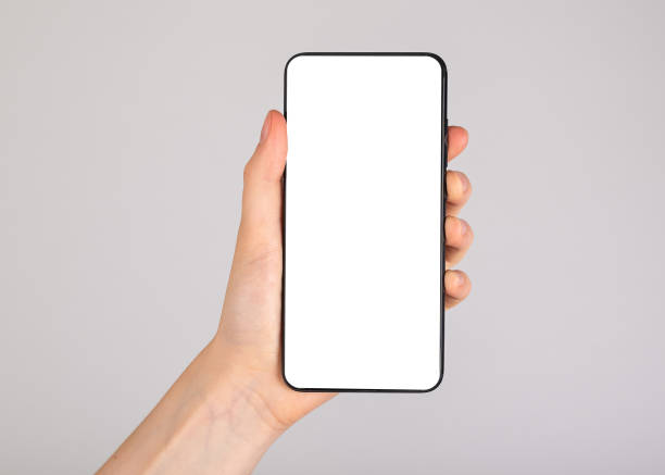istock Hand holding abstract mobile phone mockup, empty blank white screen template on gray background 1429396203