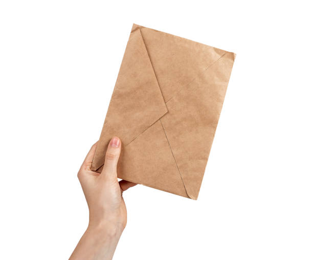 istock Craft paper envelope in hand isolated on white 1429396251