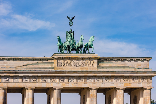 The horse team of the Quadriga on famous landmark Brandenburger Tor, Brandenburg Gate in Berlin against blue sky