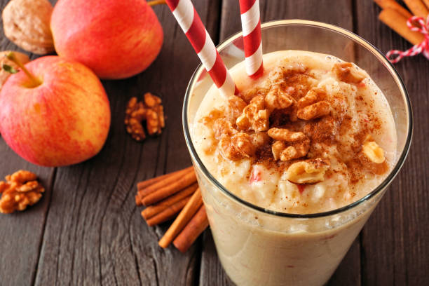 istock Apple pie smoothie close up in a glass with walnuts and cinnamon. Table scene on a rustic dark wood background. 1429409134