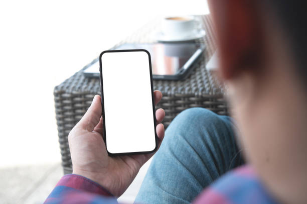 istock Cell phone blank white screen mockup. Man hands holding, using mobile phone at coffee shop, template for advertisement 1429409286