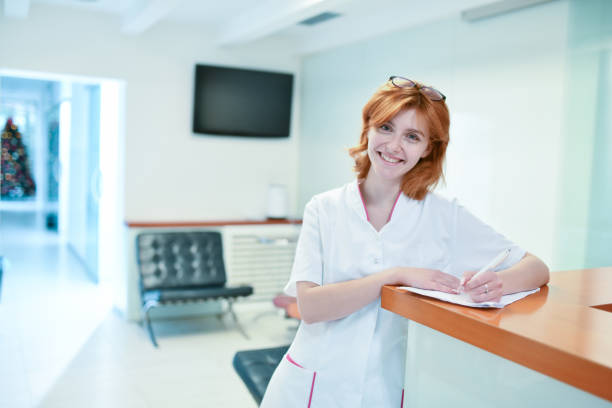 istock Smiling Redhead Female Dentist Writing Down Patient Info And Appointment 1429420119