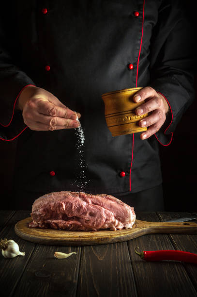 istock The chef sprinkles raw meat with salt. Preparing fresh meat before roasting. Menu concept for restaurant or hotel. European cuisine 1429421706