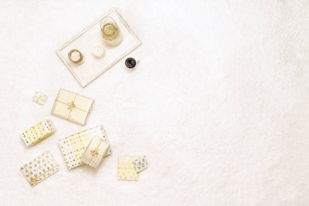 Christmas gifts boxes wrapping  in white gold paper for family lying on fluffy snow-white carpet with tray with cup of hot  chocolate and marshmallows. Copy space. Top view stock photo