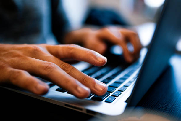 Close up man hands typing on a computer laptop keyboard stock photo