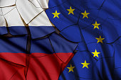 Russia vs European Union gas and oil conflict, economic concept : Russian and EU flags on a cracked wall, depicting the impact of Russia's invasion of Ukraine on the Europe and global energy market.