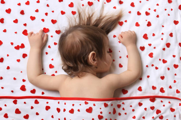 Valentine Infant An infant sleeping with lots of red hearts surrounding him on white. felt heart shape small red stock pictures, royalty-free photos & images