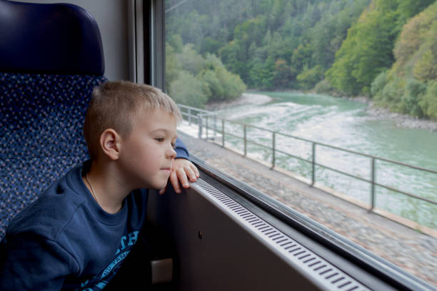 istock Little boy looks thoughtfully out the train window 1429448200