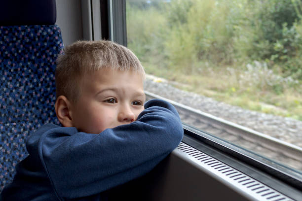 istock A little boy looks thoughtfully into the distance through the train window 1429448201