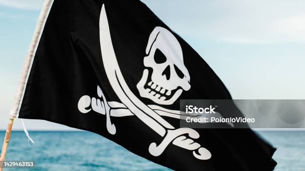 Black Pirate Flag With Skull Symbol On The Desert Island Stock Photo - Download Image Now
