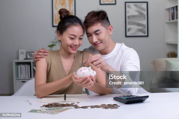 Female And Male Couple Saving Money For Family And Home Stock Photo - Download Image Now