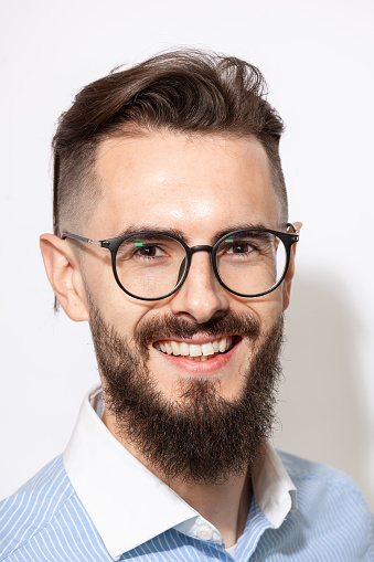 Close up studio portrait of a white 30 year old bearded man with glasses on a white background