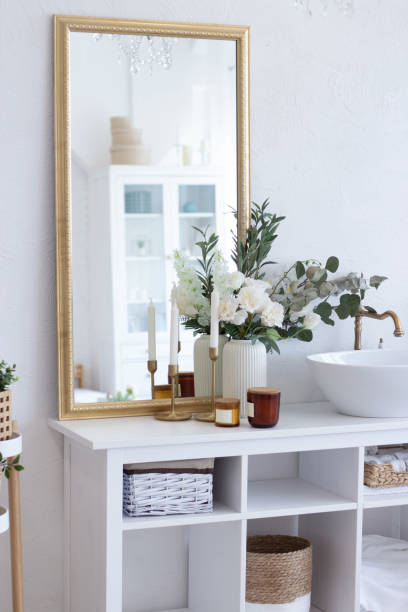 istock Beautiful bathroom interior. Large mirror in a golden frame, white shell, white flowers, candles, green flowers. Organization of space in the bathroom. 1429467214