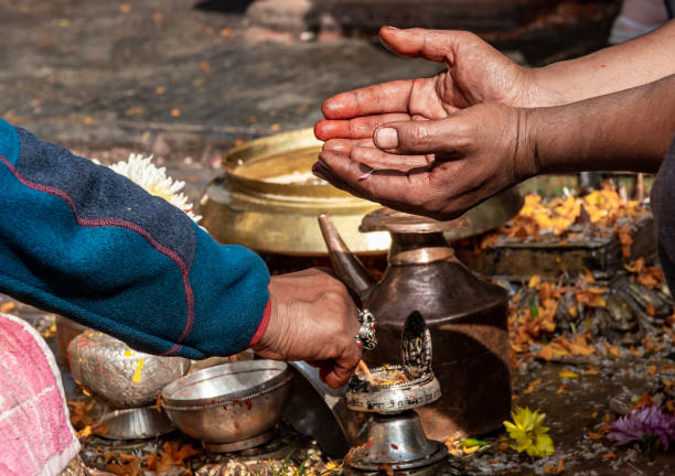 Kathmandu, Nepal - nov 6, 2019: a Buddhist worshiper holds out his hands where a monk will lay petals and tika for blessing, in the Buddhist temple Swayambhunath