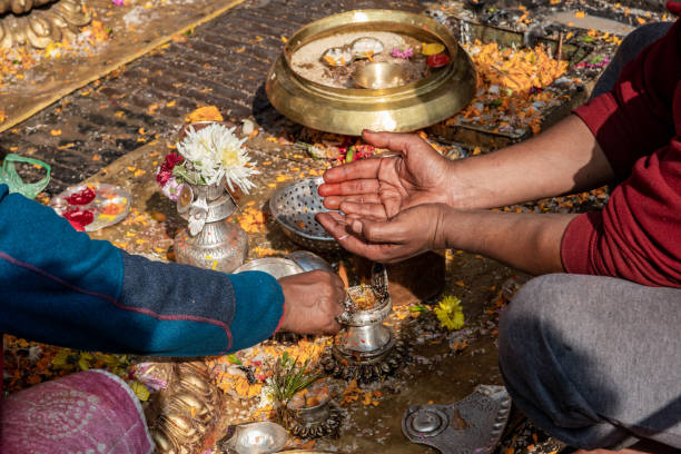 Kathmandu, Nepal - nov 6, 2019: a Buddhist worshiper holds out his hands where a monk will lay petals and tika for blessing, in the Buddhist temple Swayambhunath