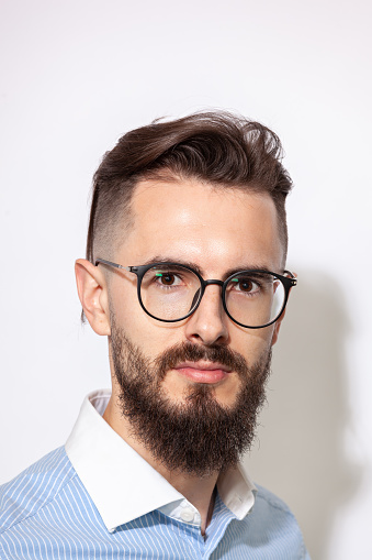 Close up studio portrait of a white 30 year old bearded man with glasses on a white background