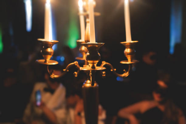istock Vintage retro brass candlesticks with candles burning, luxury event banquet table setting decoration in a restaurant hall, atmosphere with candleholder, candle fire with guests on masquerade party 1429485368