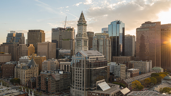 Boston city skyscrapers with historic Custom House Clock Tower at the backdrop and Faneuil Hall Marketplace at the front.