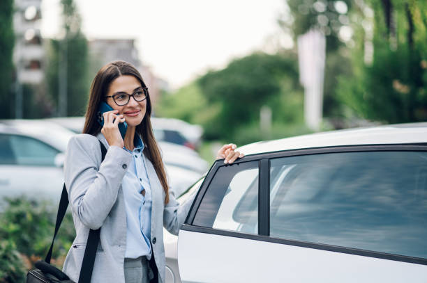 istock Business woman getting into the car and using smartphone 1429488949