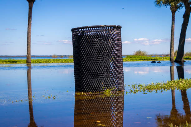 Trash can in flood water stock photo