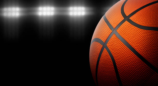 istock Basketball on a black background under stadium lights 1429510964