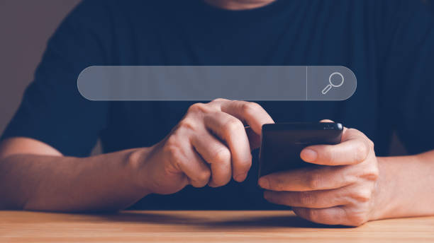 istock Man search internet online by hand hold smart phone. 1429524038