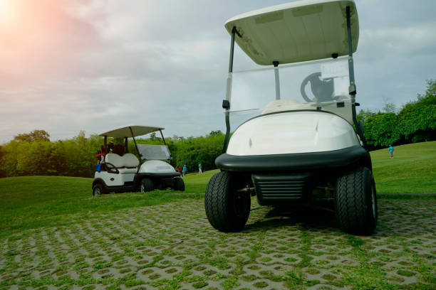 golfcar dans un beau parcours de golf dans le parcours de golf du soir avec soleil - golf cart golf bag horizontal outdoors photos et images de collection