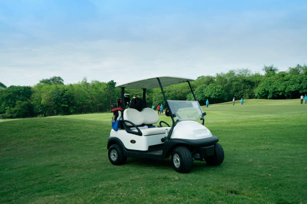 golfcar dans un beau parcours de golf dans le parcours de golf du soir avec soleil - golf cart golf bag horizontal outdoors photos et images de collection