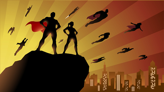 A silhouette style vector illustration of a team of superheroes flying in the sky with city skyline and sunburst effect in the background. Wide space available for your copy.
