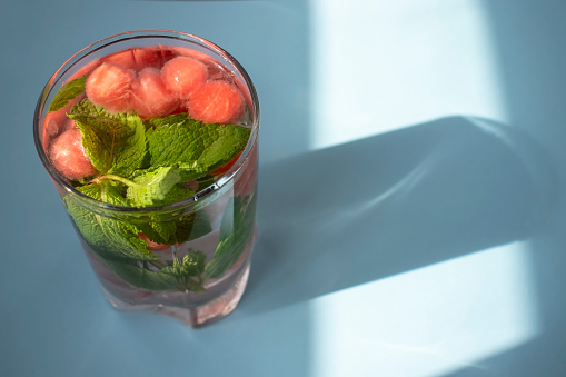 Infused water with fresh raspberries, lemon, pomegranate and mint served in a glass jar.