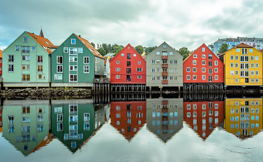 The inner city's iconic waterside warehouses by the river Nidelven , one of the most distinctive historical vernacular building types in Trondheim, Norway.