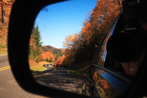 winding road in a car side view mirror, at Smoky Mountains National Park in fall