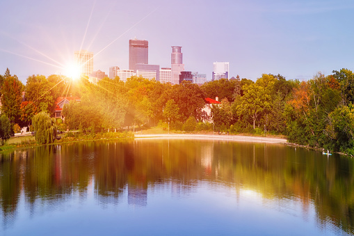 Downtown Minneapolis Skyline behind Lake of the Isles with sunbeams